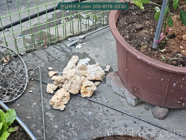 배관에서 걷어낸 석회 덩어리를 바닥에 모은 모습
