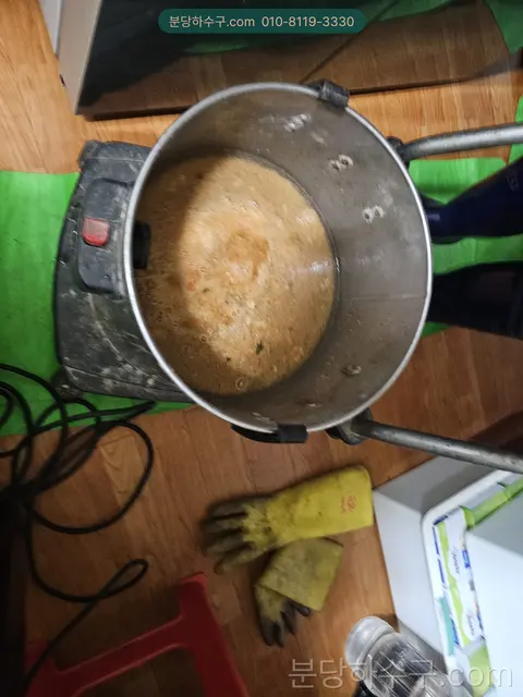 싱크 하부 배관에서 걷어낸 슬러지가 담긴 통