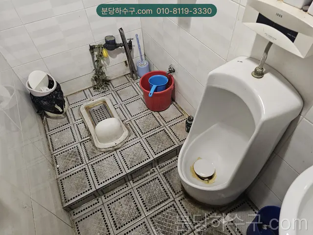상가 화장실 소변기와 바닥 배수구