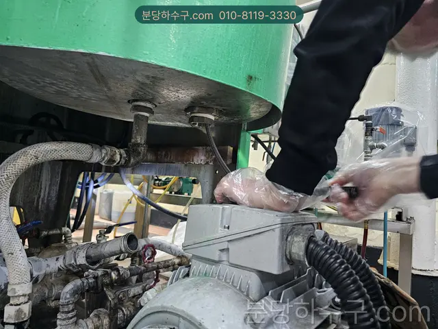 펌프 모터 단자함을 열어 결선을 확인하는 손
