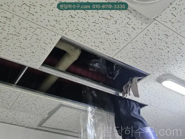 천장 위 배관을 점검구에서 확인하는 모습